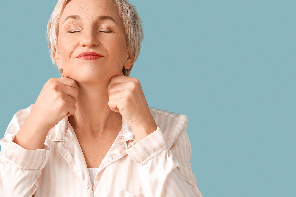 mature woman in pajamas doing face building exercise