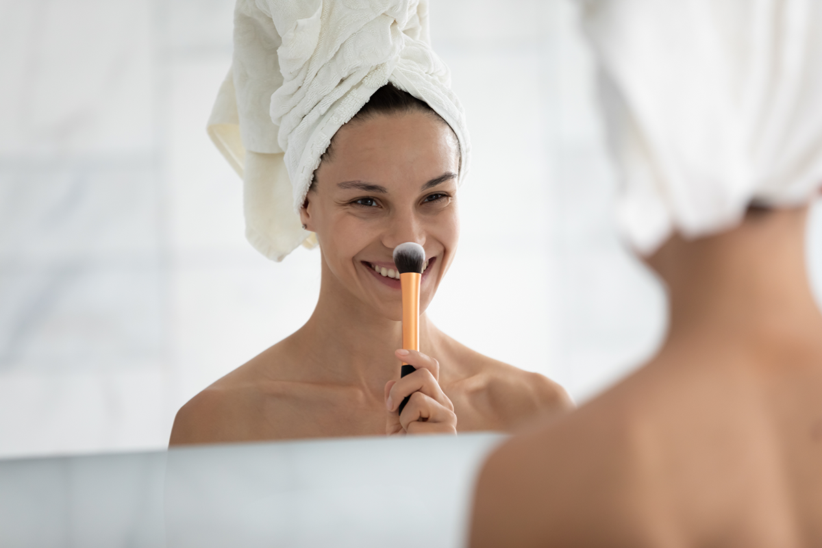 smiling woman putting daily makeup